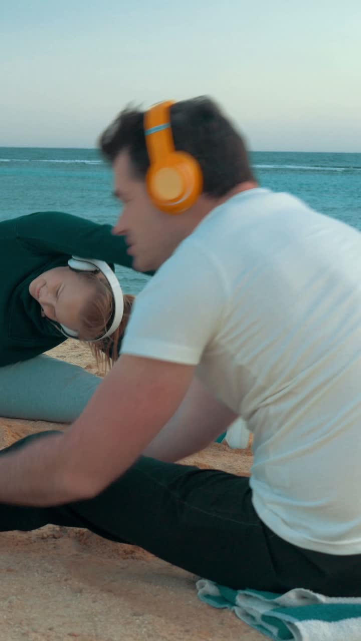Woman Stretching on the Beach with Headphones