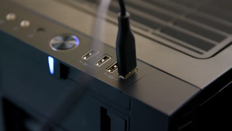 el hombre conecta varios cables usb a la computadora de escritorio