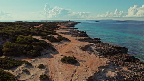 Luftaufnahme-über-Der-Spanischen-Küste-Mit-Fernblick-Auf-Torre-De-Ses-Portes-Auf-Den-Balearen,-Spanien