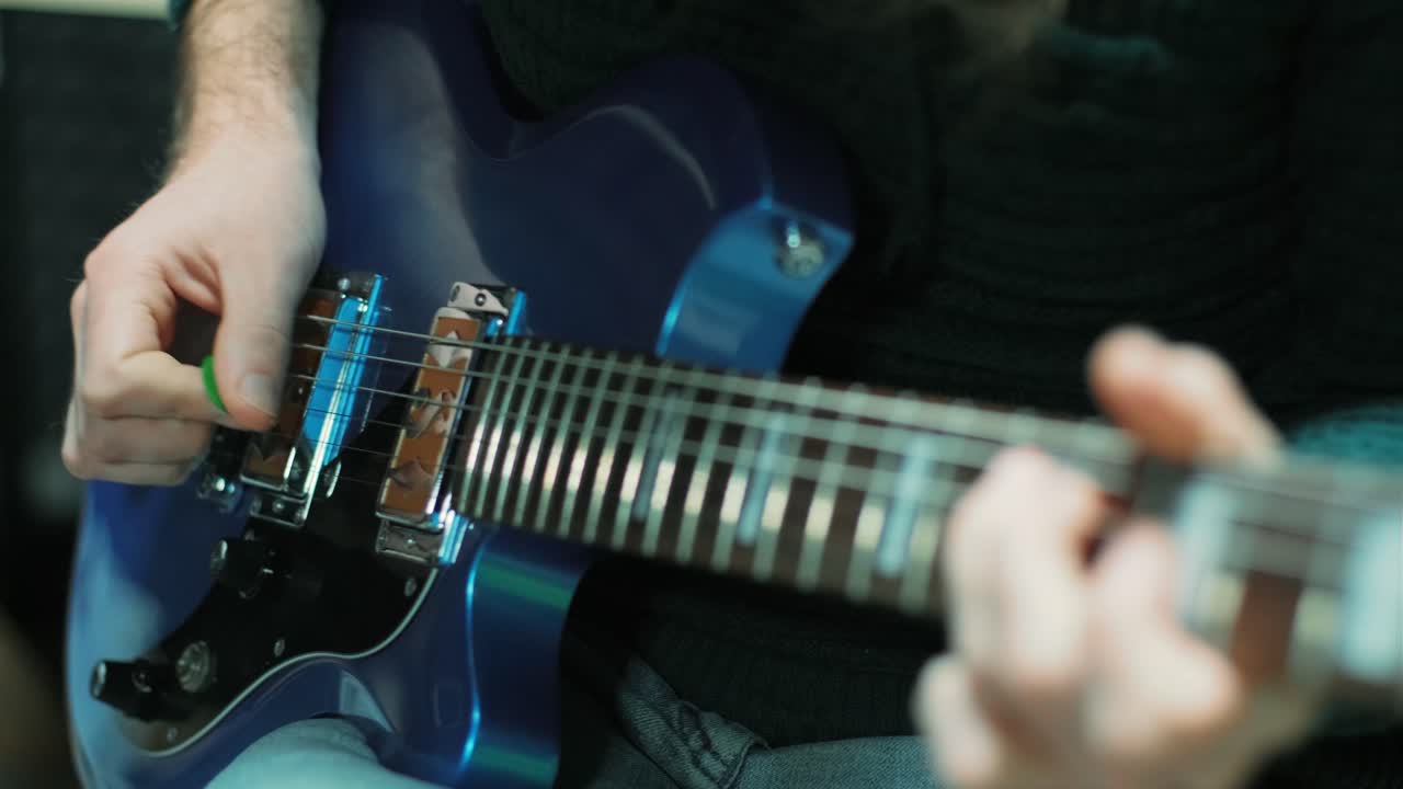 Gitar çalma alıştırması yapmak. Yakışıklı genç adam gitar çalıyor