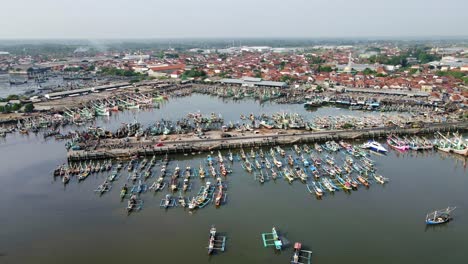 the view of muncar port, packed with old-style boats parked there, shows the biggest traditional fish port in java