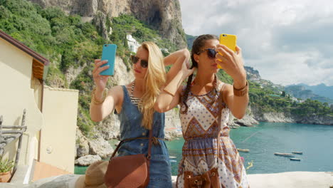 two friends taking selfies by the sea