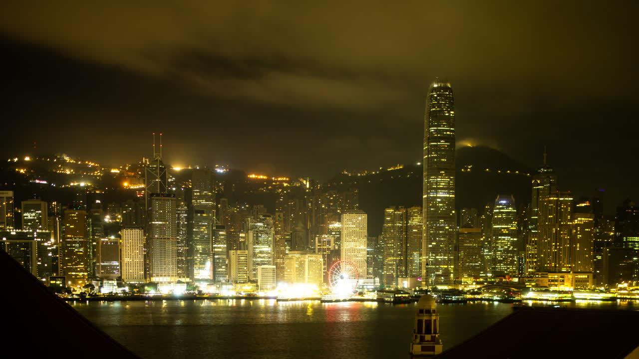 HONG KONG - 19 MARCH 2025 : Hong Kong Central city skyline filmed from across the harbour in kowloon with all the skyscrapers lit up at night advertisements