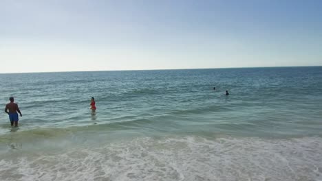 Mehrere-Leute,-Die-Im-Ozean-Auf-Anna-Maria-Island,-Florida,-Spazieren-Gehen