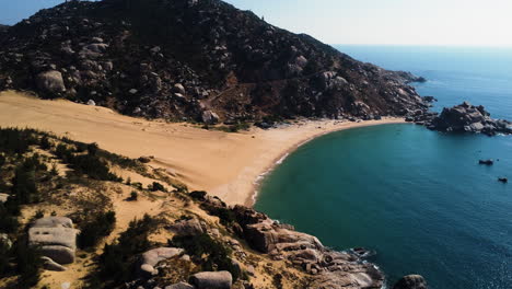 aproximación de drones arena dorada playa tropical paraíso en mui dinh, bahía vietnam destino de viaje de vacaciones costa aérea vista panorámica con rocas acantiladas montañas