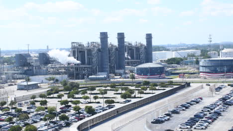 Discover-vast-clean-energy-natural-gas-plant-emitting-white-smoke,-accompanied-by-the-USA-Flag-waving-in-the-video-background,-symbolizing-renewable-energy-and-national-values