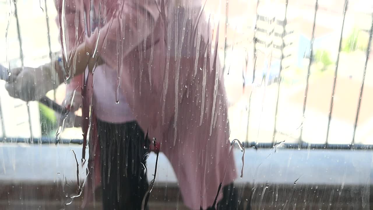 발코니 의 창문 을 청소 하는 여자