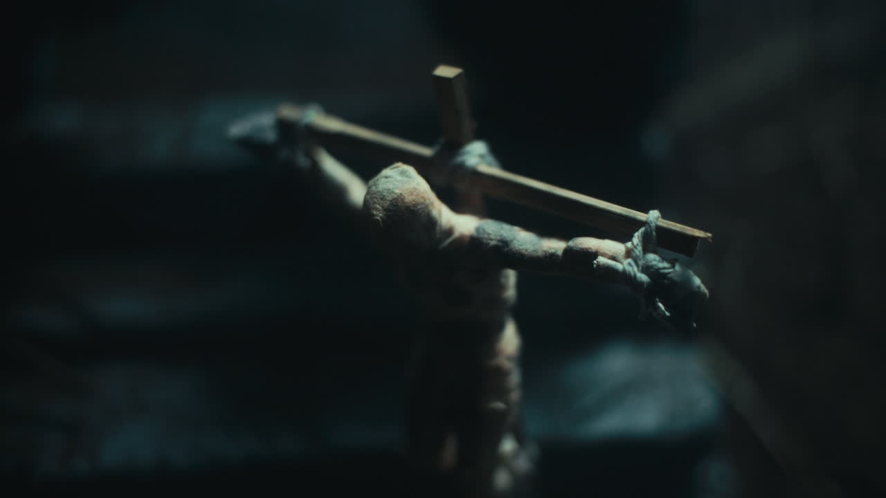 Miniature mummified dolls hanging on the gallows at night