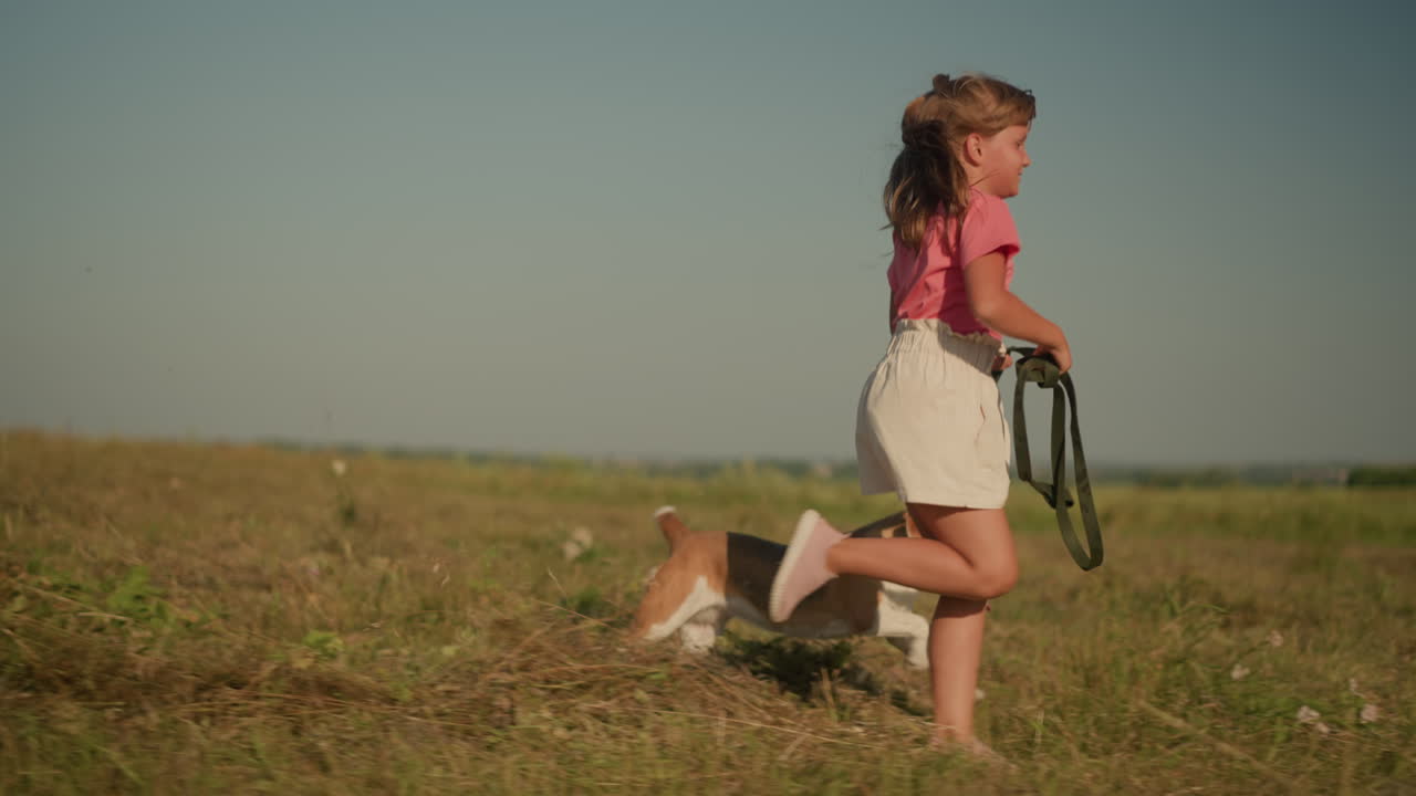 Young girl running with her dog on leash in sunny farmland, enjoying outdoor activity, scene depicts energy, fun, and adventure, emphasizing bond between child and pet