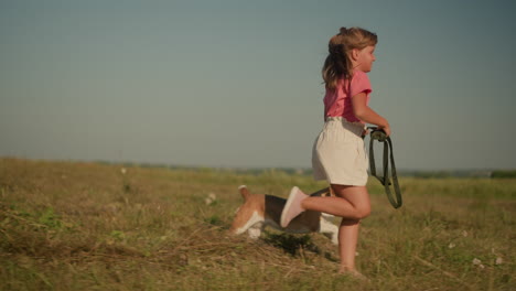 young girl running with her dog on leash in sunny farmland, enjoying outdoor activity, scene depicts energy, fun, and adventure, emphasizing bond between child and pet