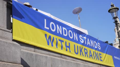 london stands with ukraine, banner of solidarity and support in trafalgar square in london during protest against war with russia