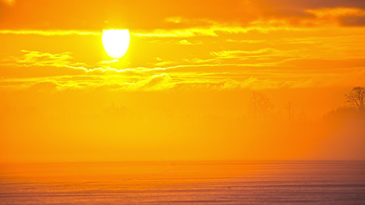 아침에 일출 동안 야외에서 눈이 덮인 들판이 있는 시골 눈 덮인 풍경에서 황금시간 동안 날아다니는 구름의 시간 경과 - 안개와 안개가 시골 위로 떠다니는 - 파노라마 시간 경과