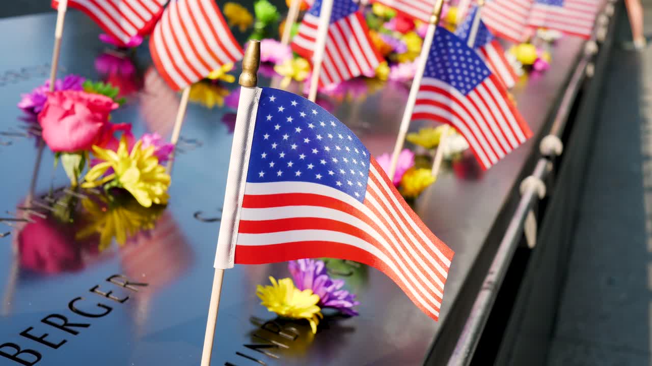 Slow motion American USA Flags and flowers at the September 11 site monument memorial Ground Zero New York City USA America remembrance patriotism Manhattan World Trade Center