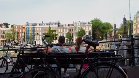 couple relaxing by amsterdam canal