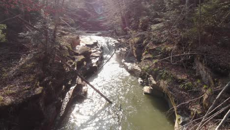 aerial view of a mountain river with beautiful waterfall in the afternoon sunlight