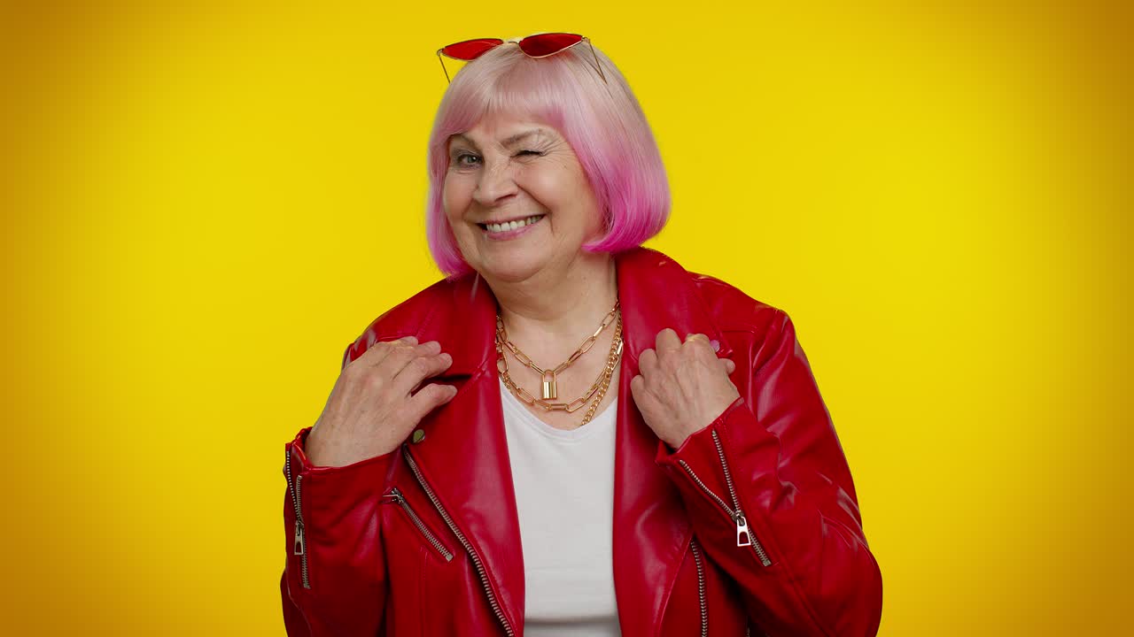 Anziana nonna giocosa e felice che ammicca, guardando la telecamera con un sorriso ed esprimendo ottimismo.