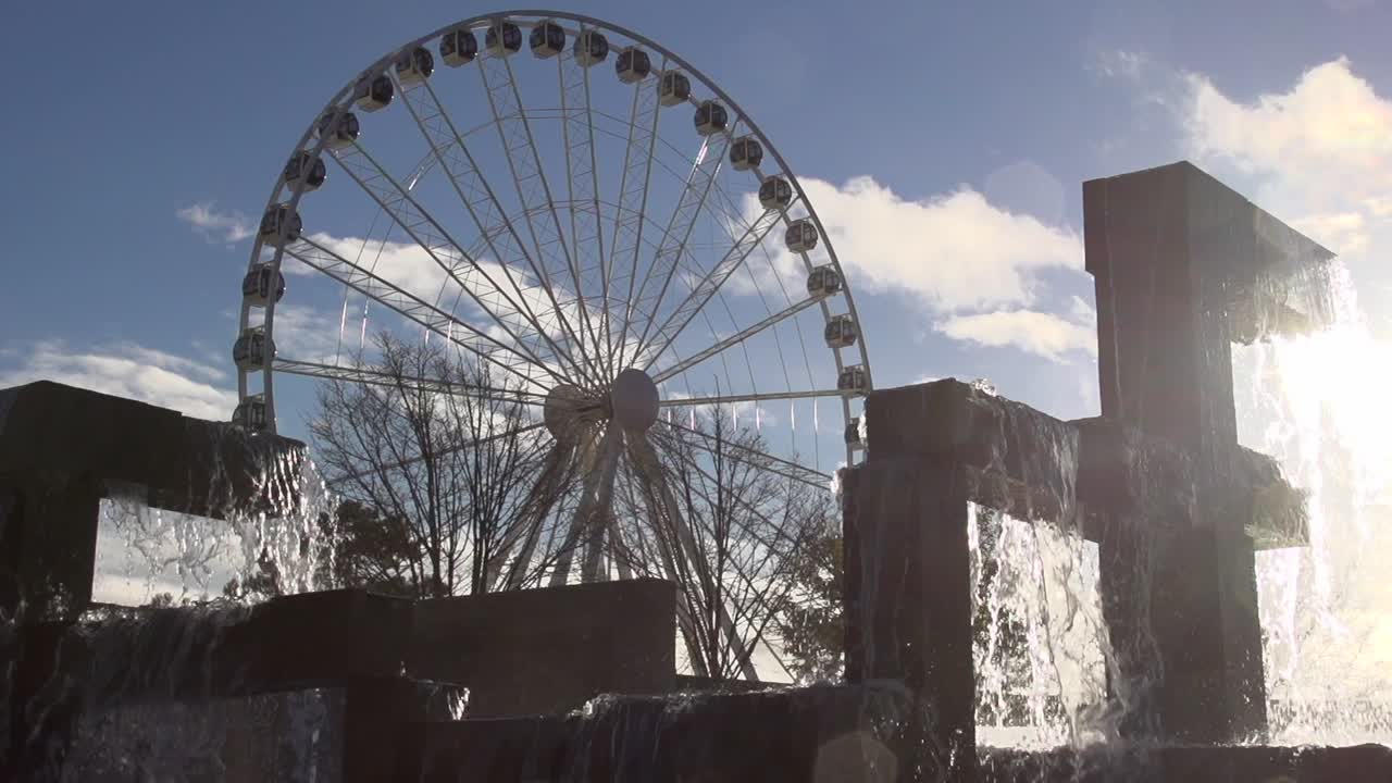 The fountain at Seattle's Waterfront Park at sunset. The Seattle Great Wheel turns in the background. Slow-motion. 

Filmed in 2013.