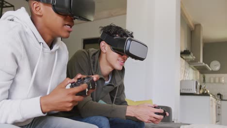 happy diverse male teenage friends playing video games and using vr headsets at home, slow motion