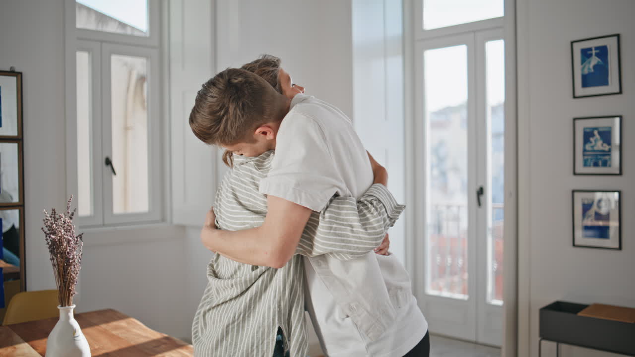 Famiglia che festeggia il trasloco nella nuova casa. Ragazza felice che lancia le chiavi e abbraccia un uomo