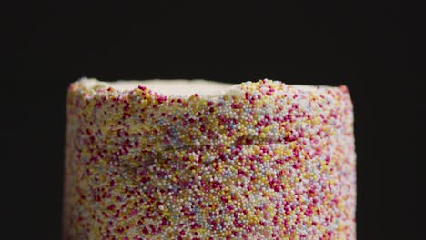 Close-Up-Studio-Shot-Of-Revolving-Birthday-Cake-Covered-With-Hundreds-And-Thousands-Decorations-5