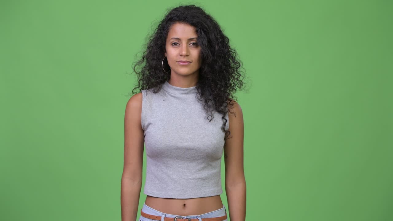 Giovane e bella donna ispanica con i capelli ricci