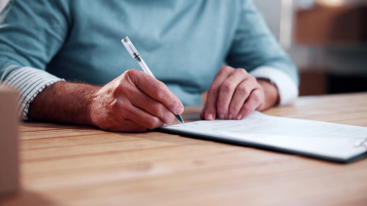 Uomo che firma un documento alla scrivania