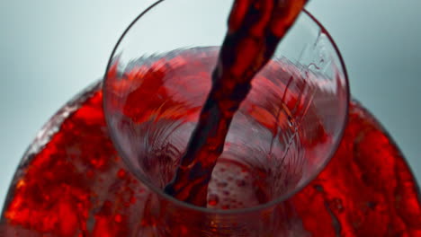 intoxicant red beverage filling decanter slow motion. wine forms waves glassware