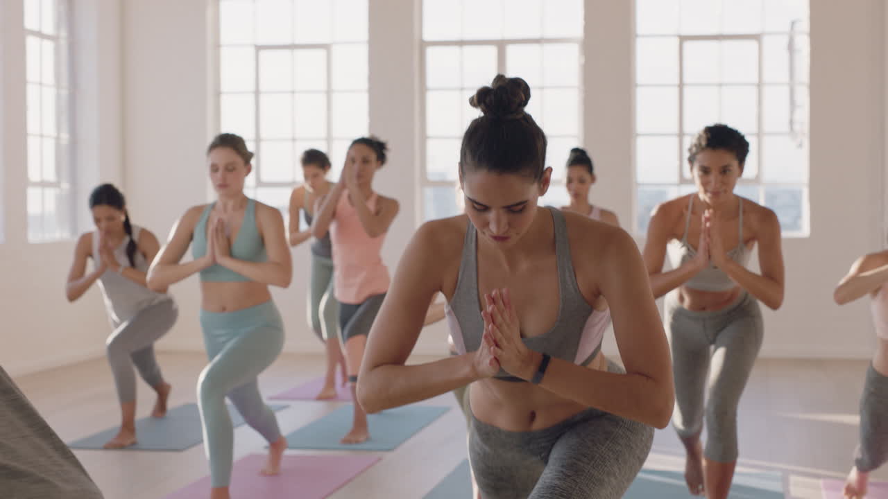 instructor de clase de yoga enseñando pose de oración a un hermoso grupo de mujeres que disfrutan de un estilo de vida saludable haciendo ejercicio en el gimnasio al amanecer