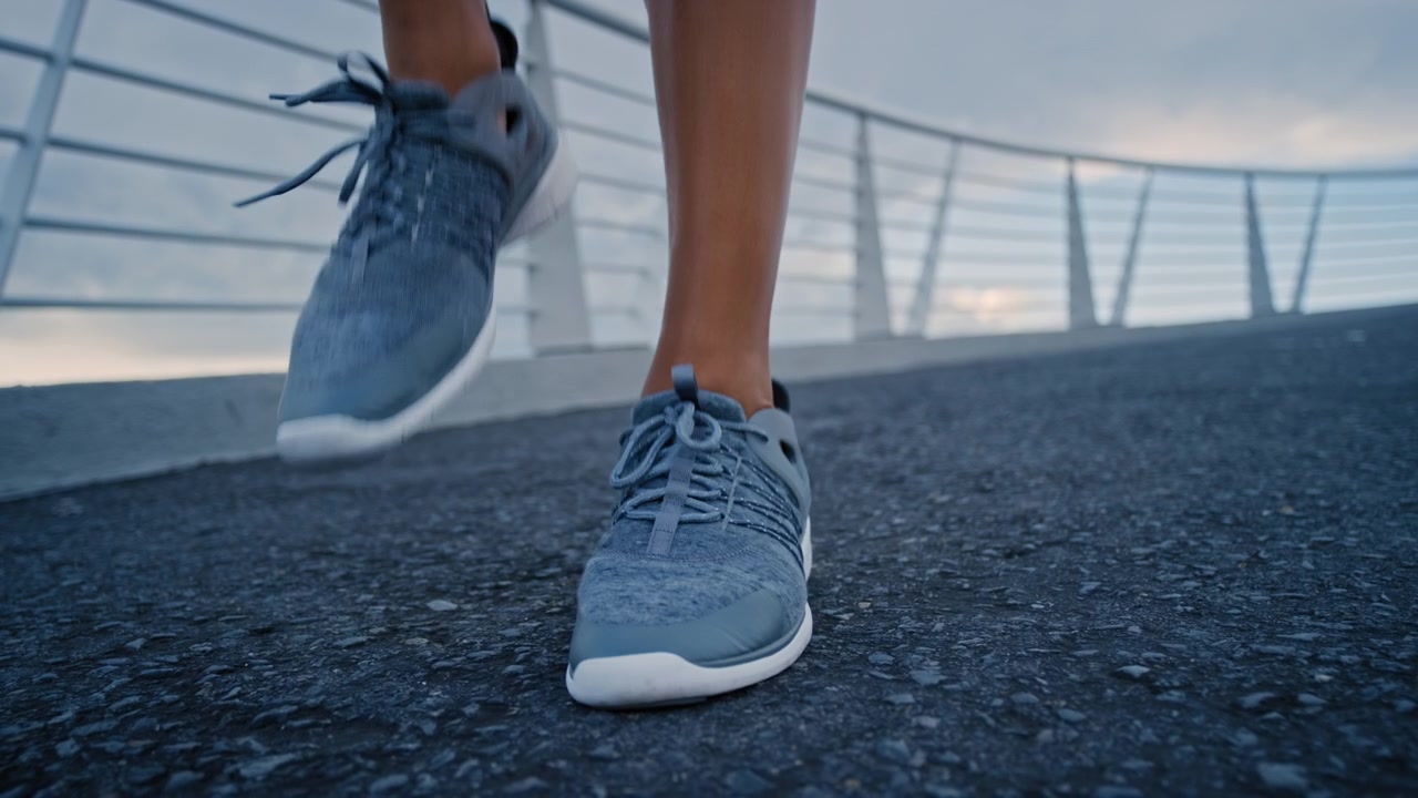 Primo piano dei piedi di un runner che corre su un ponte