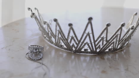 silver crown and bridal jewelry for the bride's wedding on the table - pan left