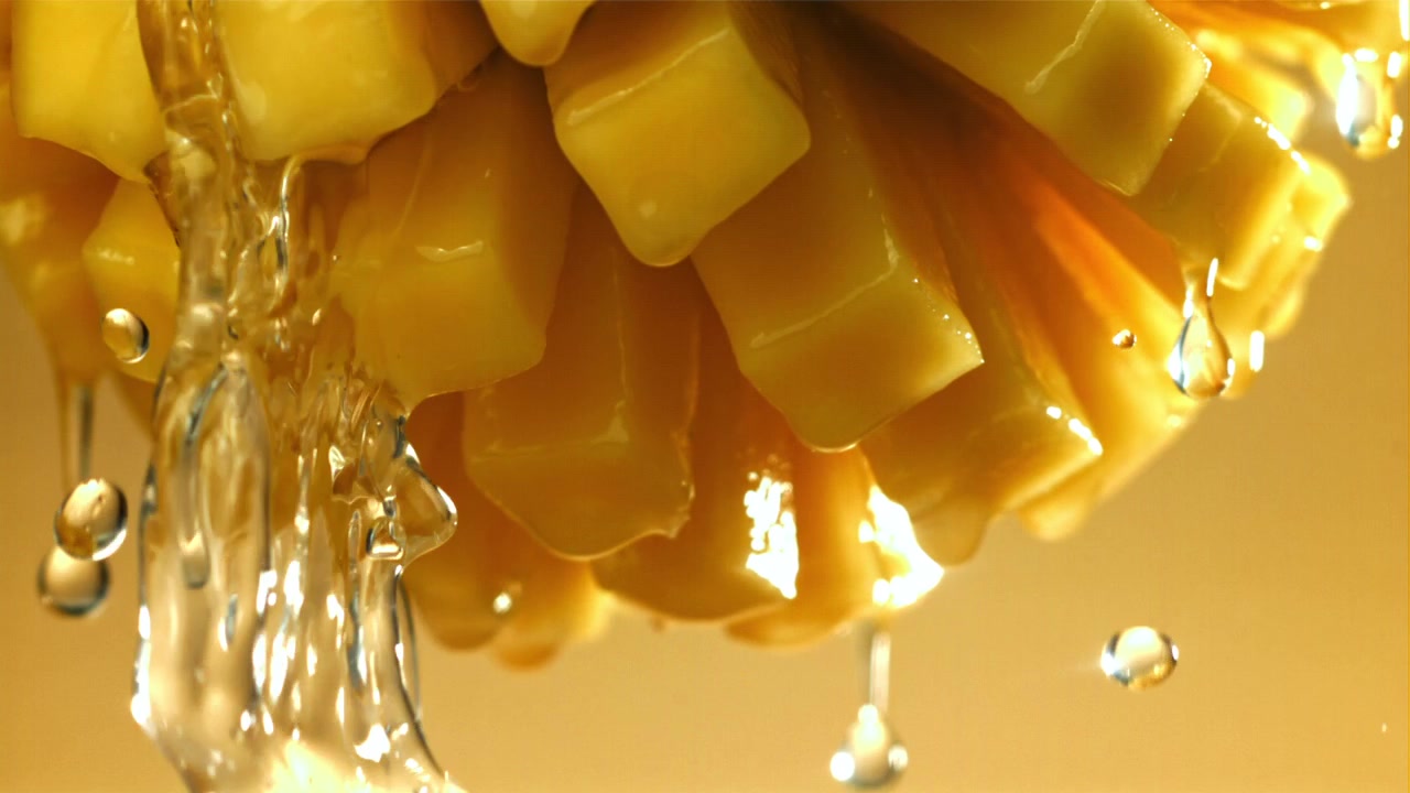 Acqua che si versa su cubetti di mango fresco