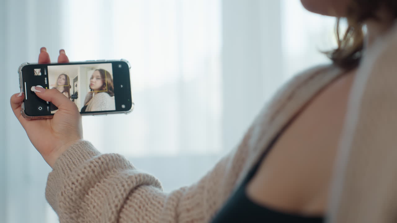 Woman Taking Selfie, Woman Carefully Editing Her Selfie Setup In Cozy Environment, Individual Adjusting Phone Angle And Composition While Dressed Comfortably Indoors During Soft Daylight