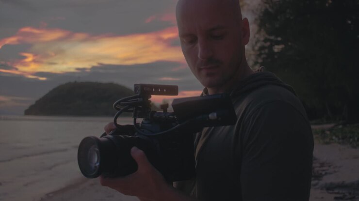 Videographer filming sunset at the beach