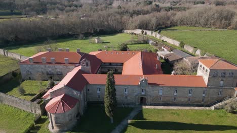 drone descends to shaded entrance flying above open private courtyard of san salvador de ferreira monastery