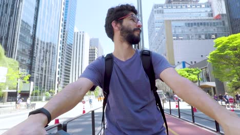 Hübscher-Junger-Bärtiger-Mann-Auf-Dem-Fahrrad,-Der-An-Einem-Schönen-Sonnigen-Tag-Auf-Dem-Radweg-Der-Paulista-Avenue-Steht