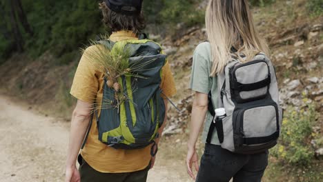 Unrecognizable couple backpackers walking by forest&#039;s rocky path