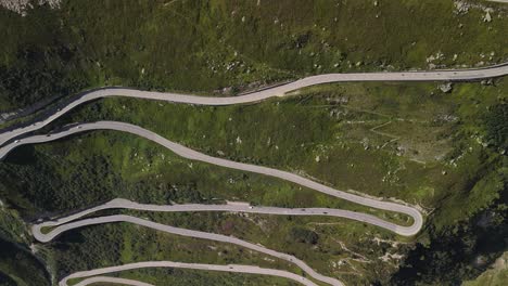 top-down aerial view of serpentine roads meandering through the mountainous region near lake totensee in obergoms, switzerland, highlighting the complex route through the rugged alpine landscape