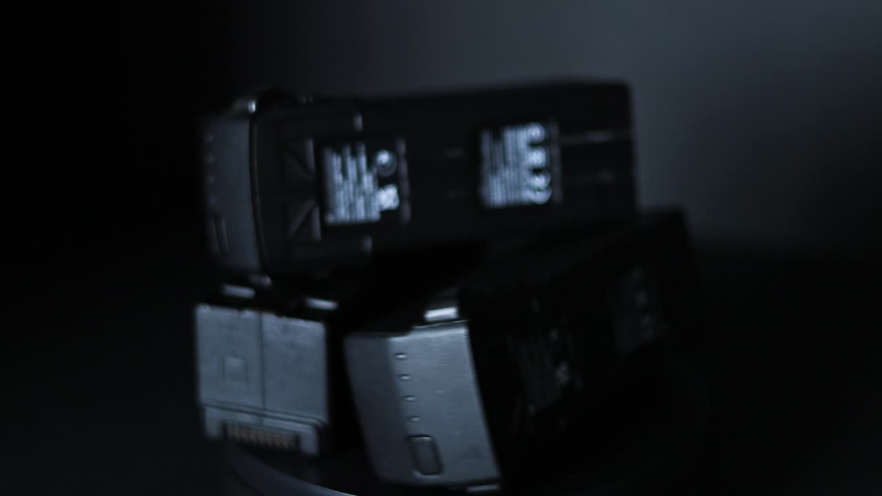 3개의 검은색 uas 드론 배터리가 검은색 배경에 360도 회전한다.