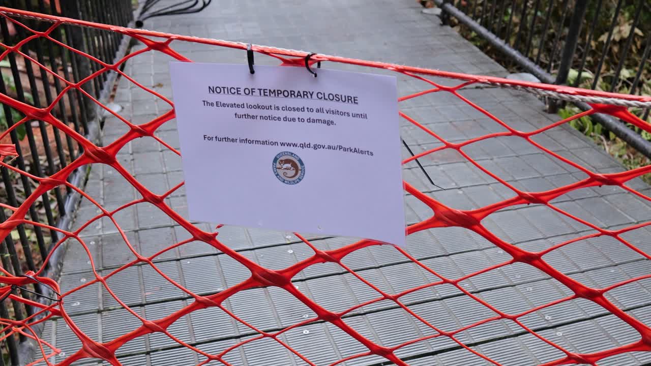 A closed pathway in Mossman Gorge, Daintree Rainforest, with warning signs and barriers under overcast lighting