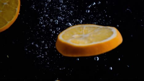 rodajas de naranja cayendo en cámara superlenta de agua, fondo negro, muchas burbujas de aire, 4k240fps