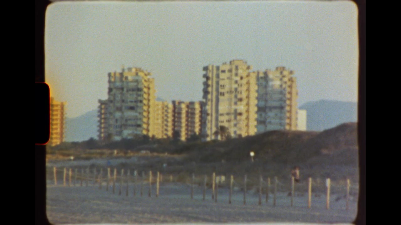 Edifici residenziali che si affacciano su una spiaggia sabbiosa al tramonto