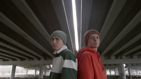 portrait of two parkourists under urban bridge