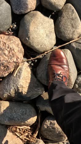 walking on rocky ground: foot in shoe navigating uneven surface