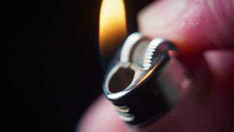 super slow motion macro shot of a lighter being lit in the dark, with a flame coming out