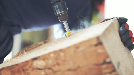 carpintero usando una máquina perforadora en madera