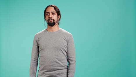 retrato de un hombre serio de pie aislado contra el fondo azul del estudio