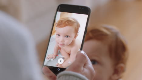 mother taking photo of baby using smartphone enjoying photographing cute toddler sharing motherhood lifestyle on social media
