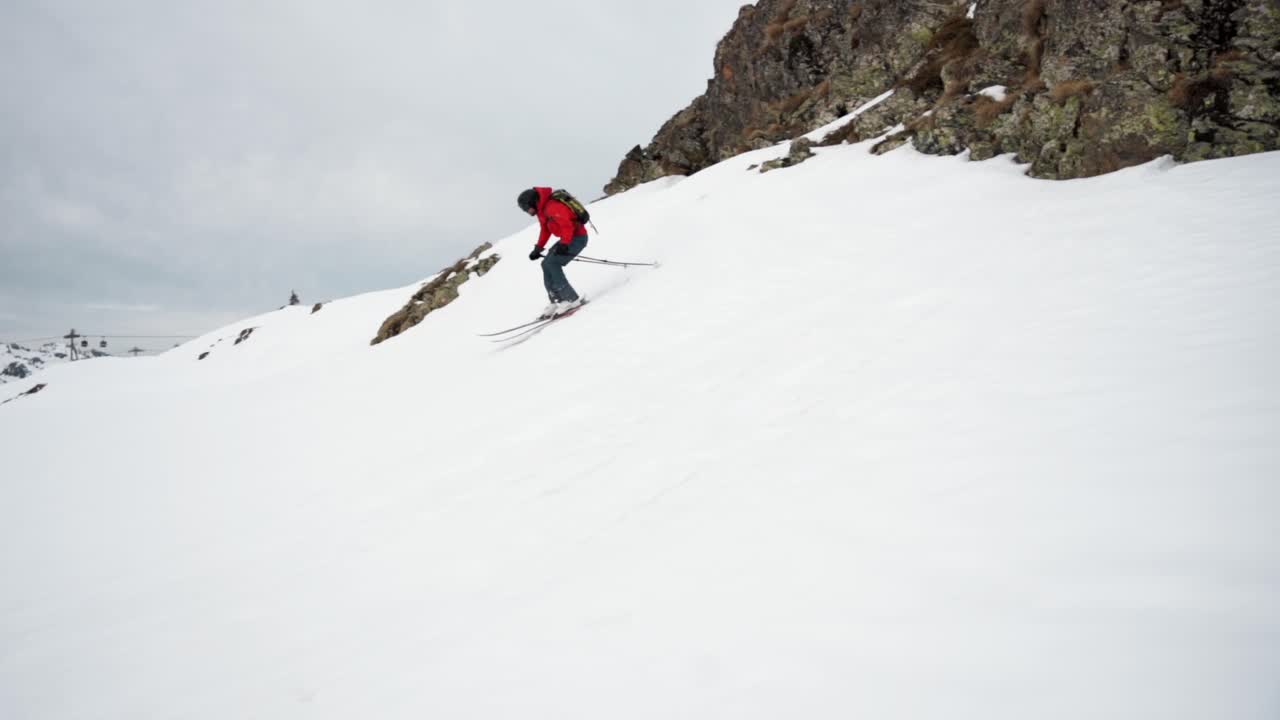 Freeskier che salta giù dal cornicione in inverno