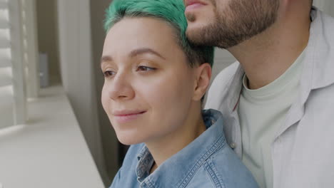 close up of a handsome man tenderly hugging his girlfriend from the back at home 2