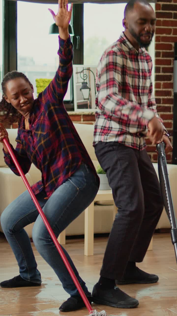 Vertical video: Cheerful people showing dance moves and doing spring cleaning